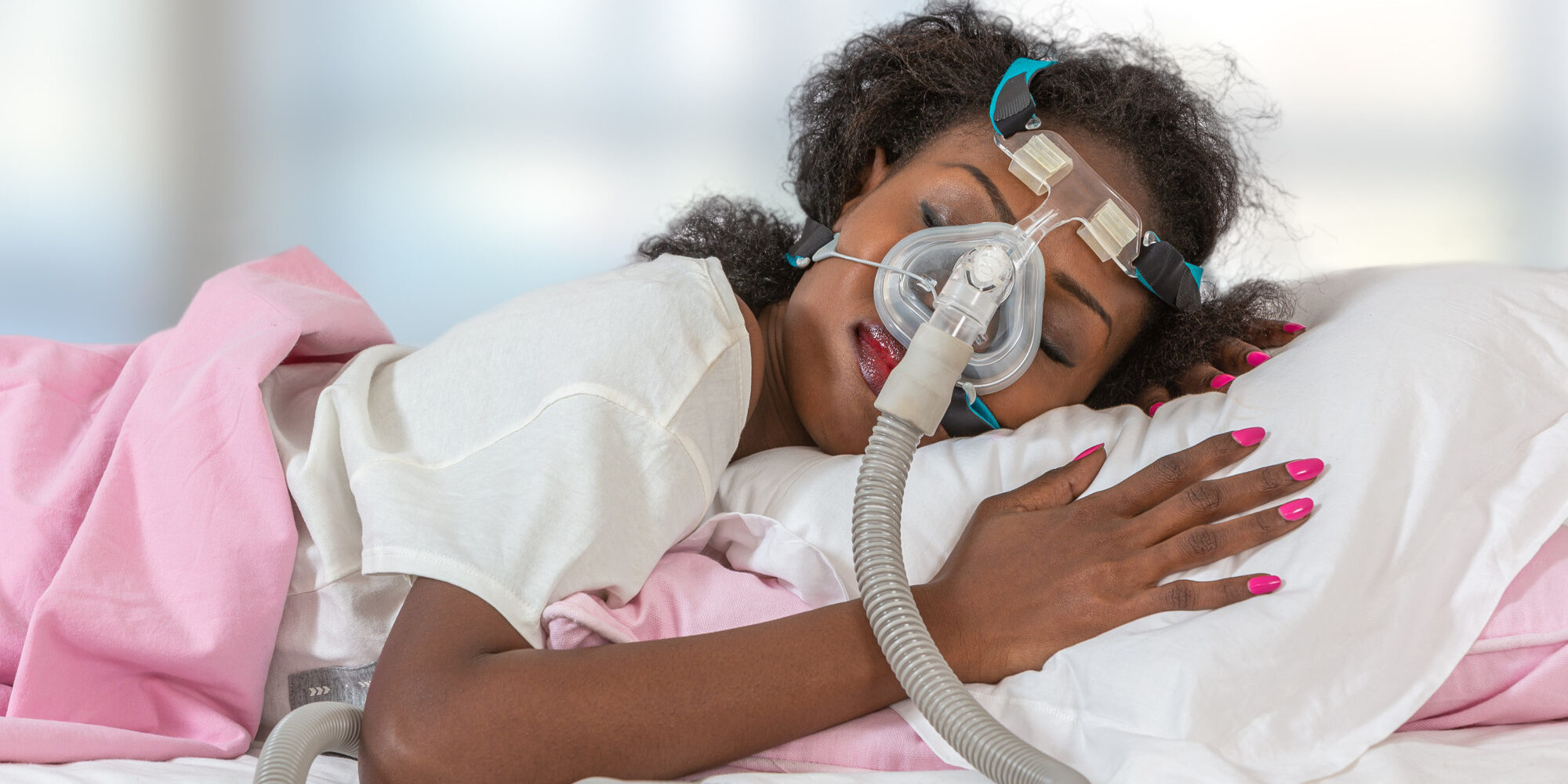 Woman wearing CPAP headgear to sleep against apnea